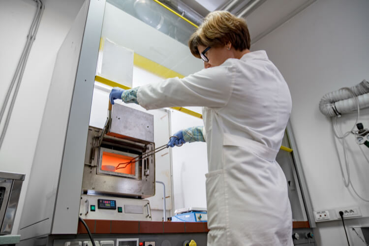 Lab technician loading sample into high-temperature sintering furnace